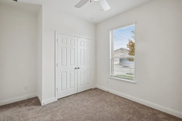 an empty room with windows and closet