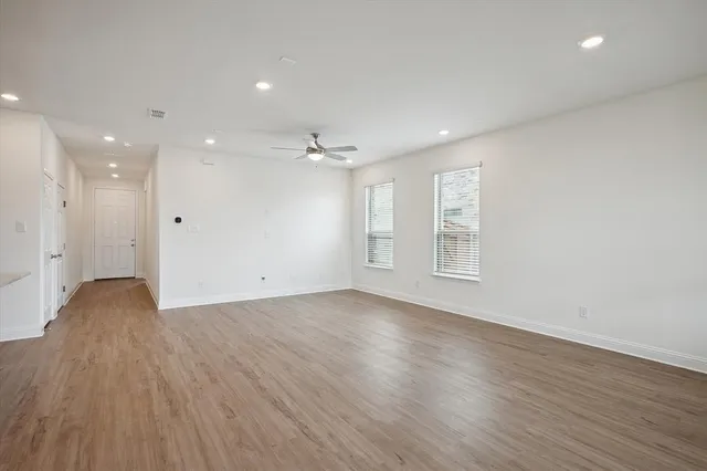 a view of an empty room with wooden floor