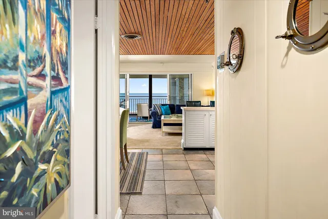 a kitchen with refrigerator a stove a dining table and chairs with wooden floors