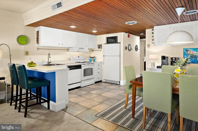 a dining room with furniture and a kitchen view