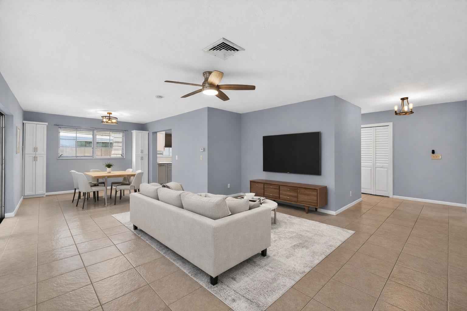 423 Pine Tree Court, Unit 23 Atlantis, FL 33462 - Photo 6 of 33 a living room with furniture and a flat screen tv