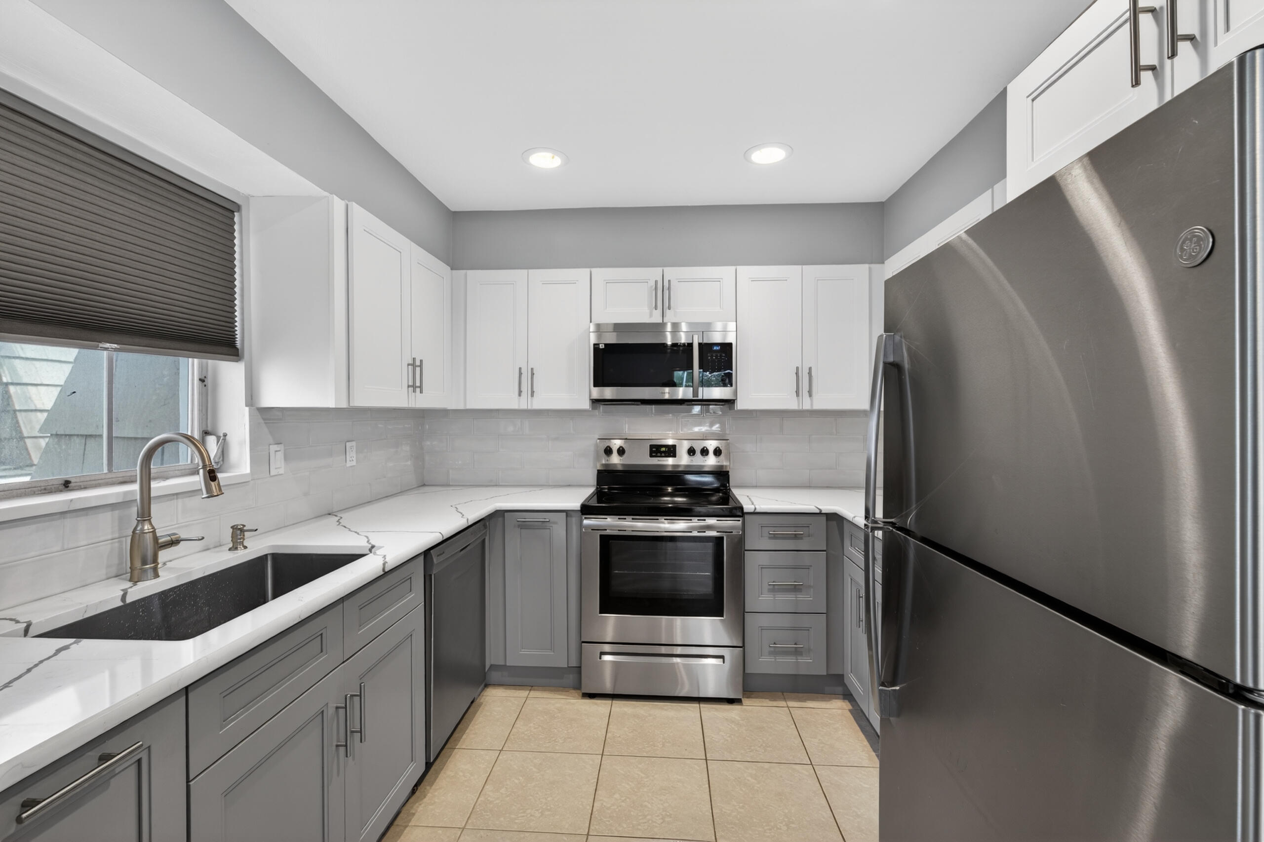 423 Pine Tree Court, Unit 23 Atlantis, FL 33462 - Photo 10 of 33 a kitchen with a sink a refrigerator and a stove top oven