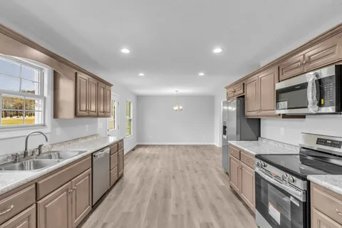 a kitchen with stainless steel appliances granite countertop a sink stove and refrigerator