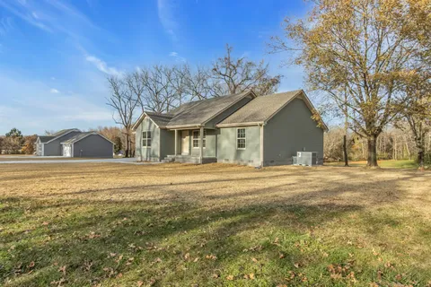 a front view of a house with a garden and trees