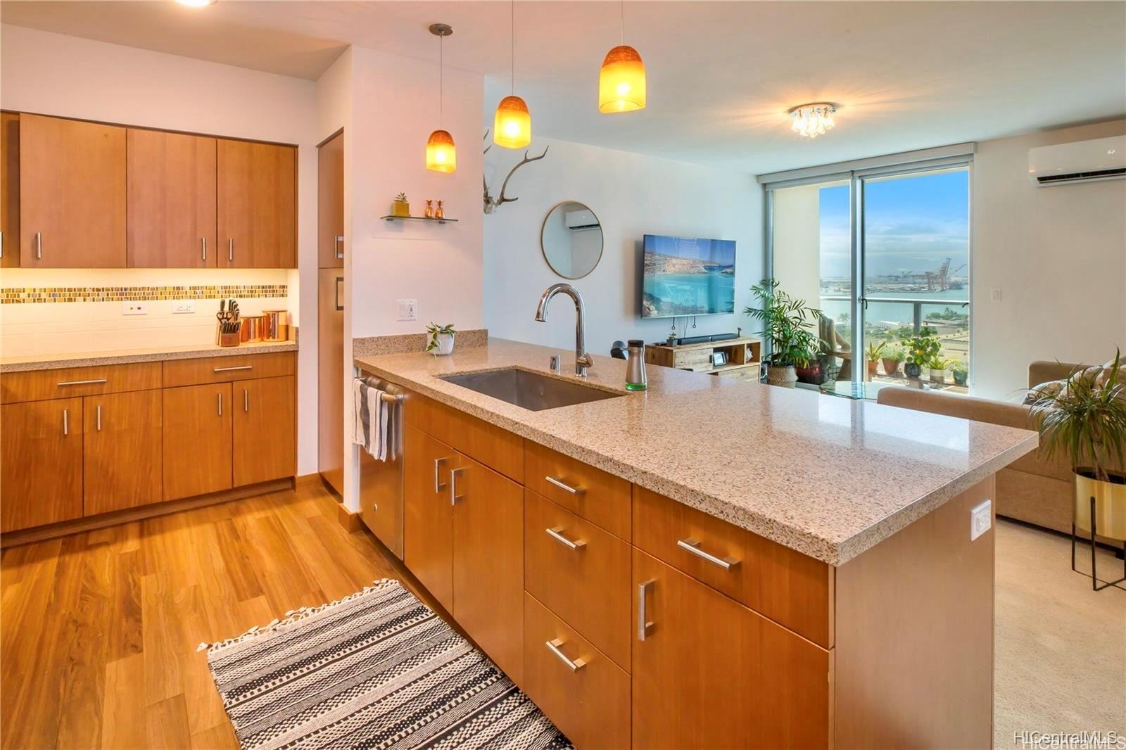 a kitchen with kitchen island granite countertop a sink cabinets and wooden floor
