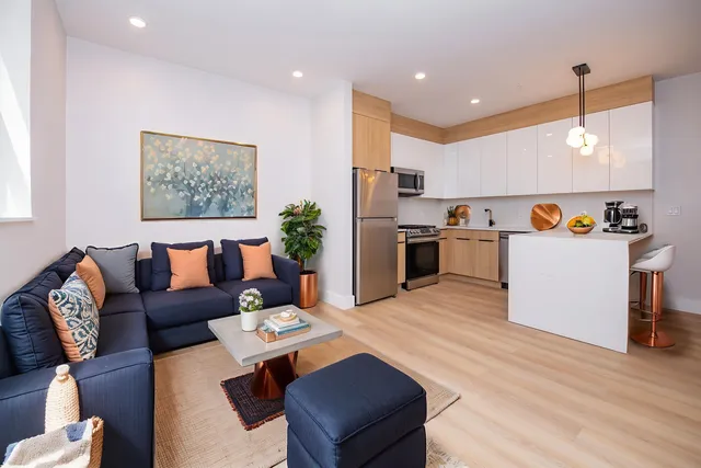 a living room with furniture and kitchen view