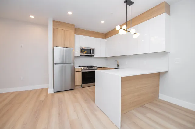 a kitchen with kitchen island white cabinets and stainless steel appliances