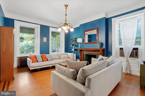 a living room with furniture a fireplace and a large window