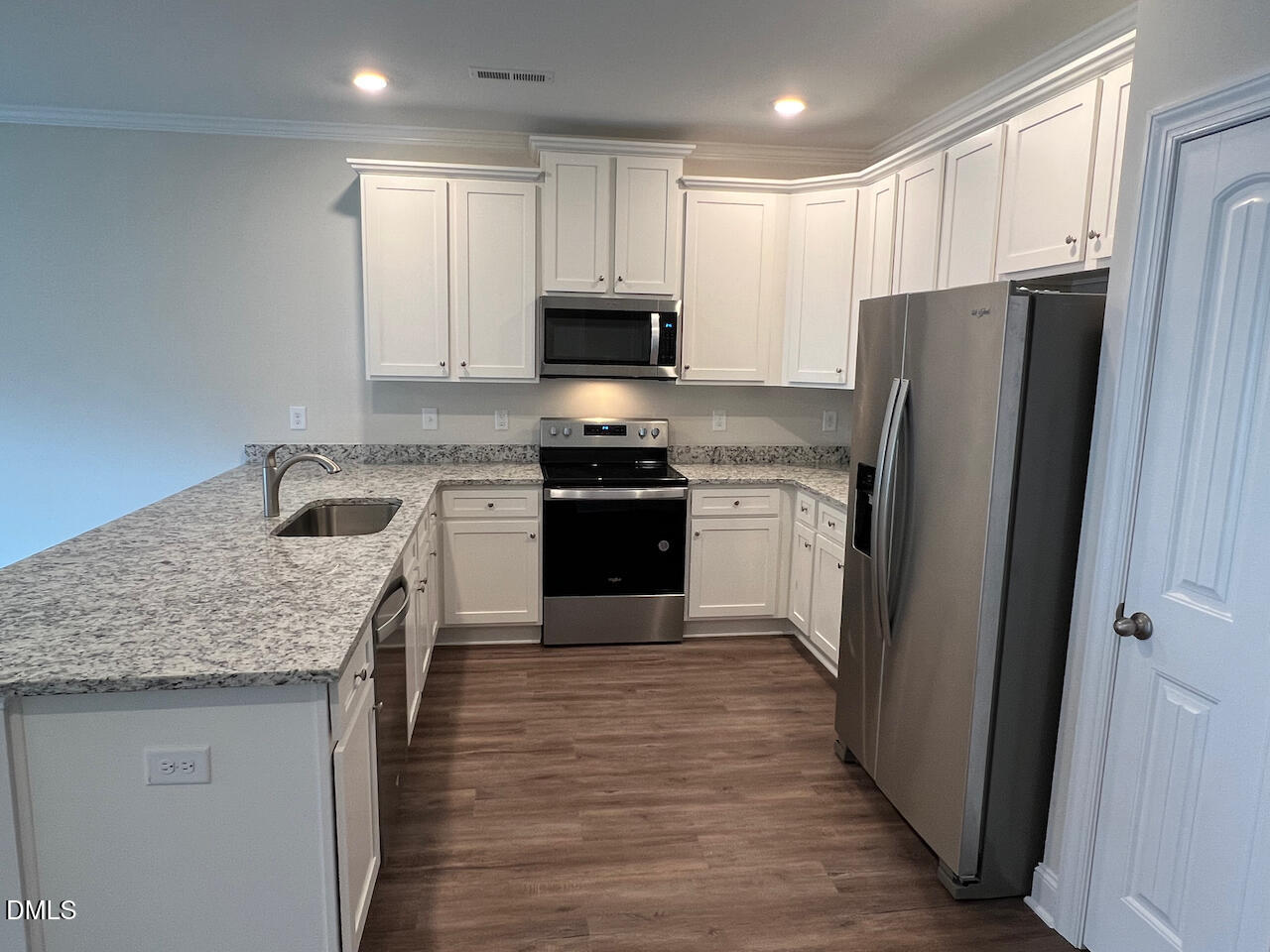 6905 Outfall Point Lane Raleigh, NC 27616 - Photo 8 of 44 a kitchen with stainless steel appliances granite countertop a stove top oven a refrigerator and a sink