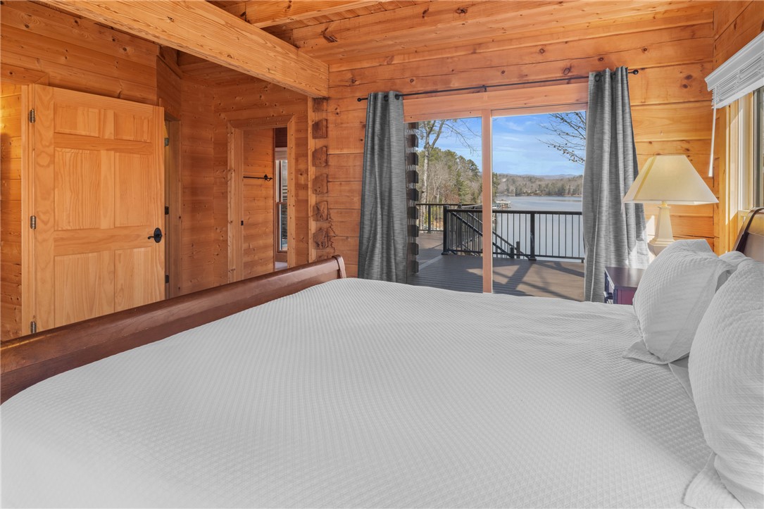 109 Deer Laurel Way Salem, SC 29676 - Photo 20 of 50 This primary bedroom offers private access to the deck, presenting panoramic lake and mountain views.
