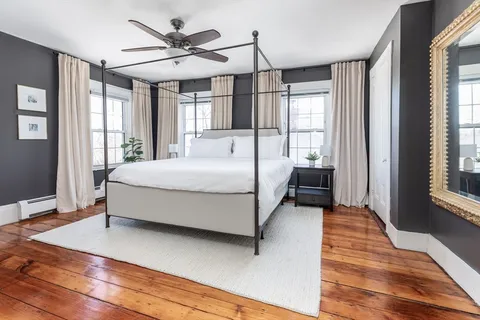 a bedroom with a bed and large windows