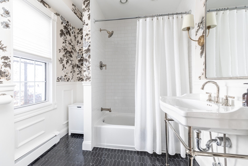 27 St James Street Boston, MA 02119 - Photo 19 of 26 a bathroom with a sink a mirror a bathtub and shower