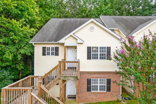 a view of a house with a yard and potted plants
