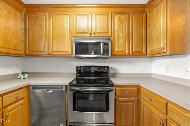 a kitchen with granite countertop cabinets stainless steel appliances and wooden cabinets