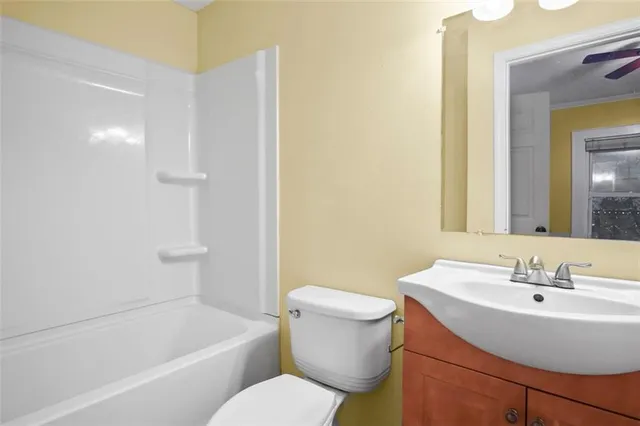 a white toilet sitting next to a white bath tub sitting next to a white sink