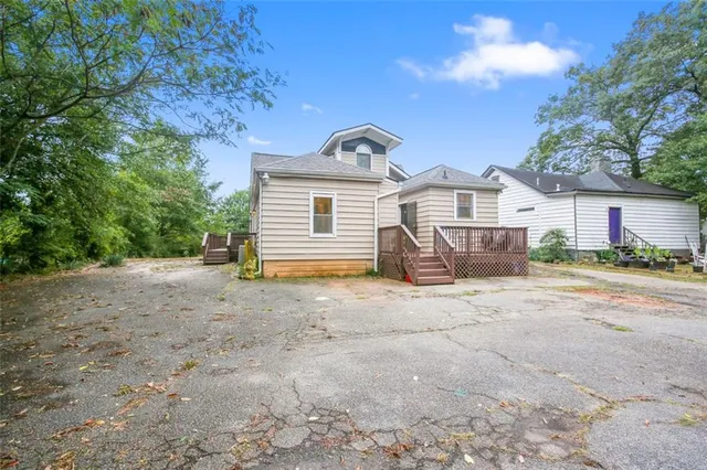 a view of a house with a yard and large tree