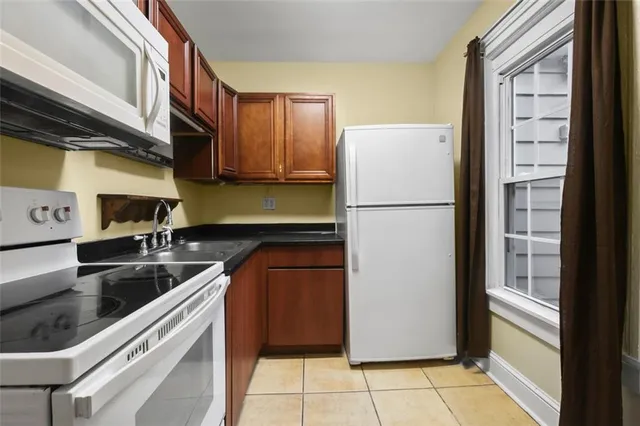 a kitchen with a refrigerator a stove top oven a sink and a window