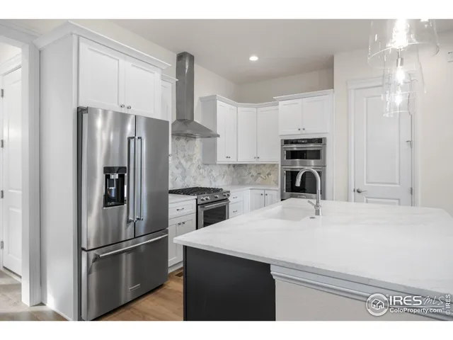 a kitchen with a sink a refrigerator and cabinets