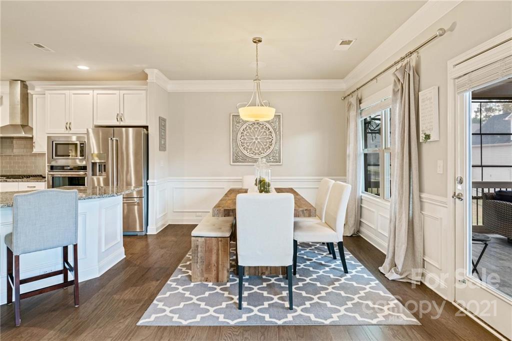 16024 Loch Raven Road Huntersville, NC 28078 - Photo 12 of 45 a dining room with furniture a rug a rug and a chandelier