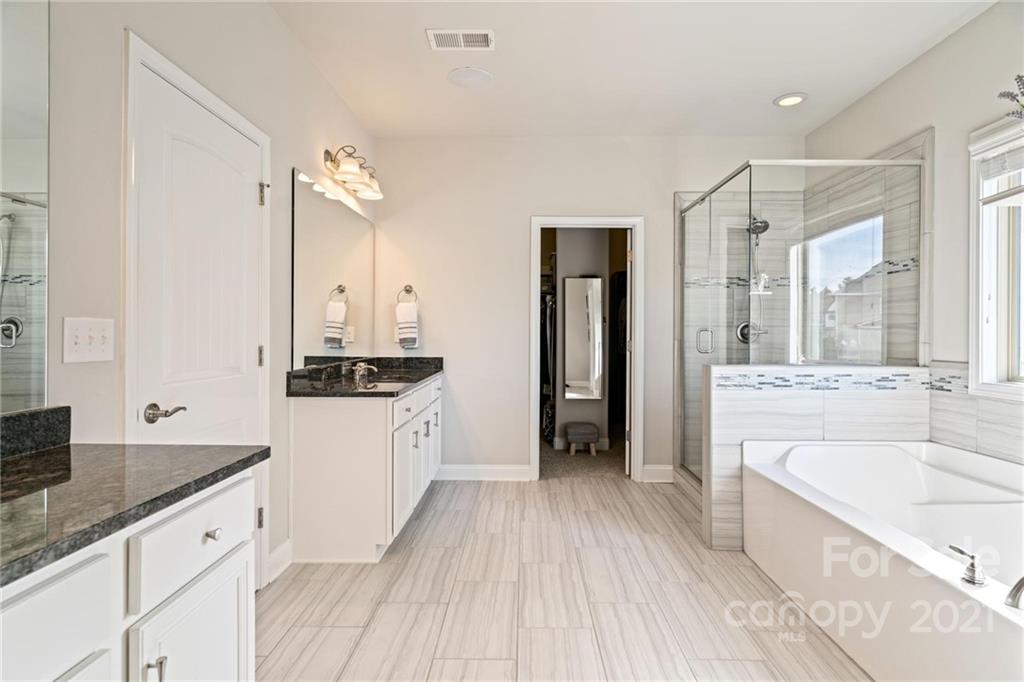 16024 Loch Raven Road Huntersville, NC 28078 - Photo 21 of 45 a large bathroom with a granite countertop double vanity sink a mirror and a bathtub
