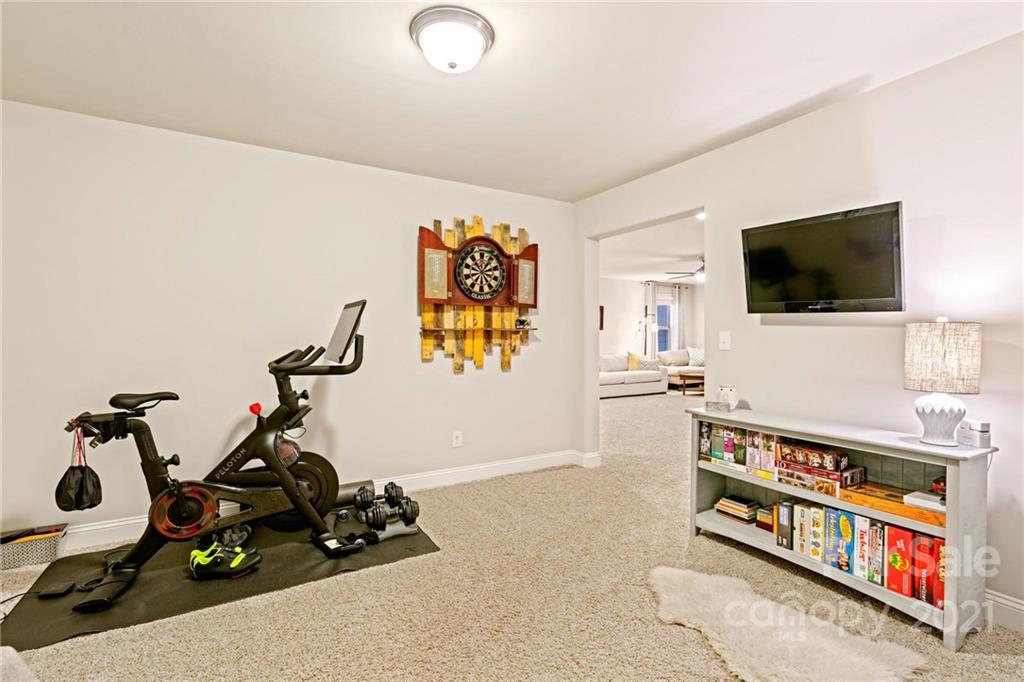 16024 Loch Raven Road Huntersville, NC 28078 - Photo 36 of 45 a room with gym equipment and a flat screen tv