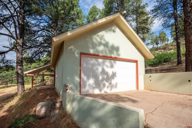 a view of small yard in front of a house with large trees