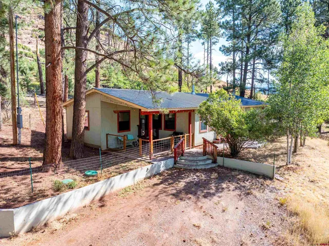 a view of a house with backyard and chairs
