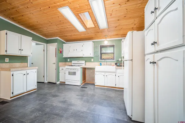 a kitchen with white cabinets and white appliances