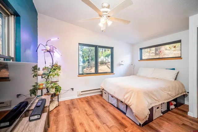 a spacious bedroom with a bed table closet and a window