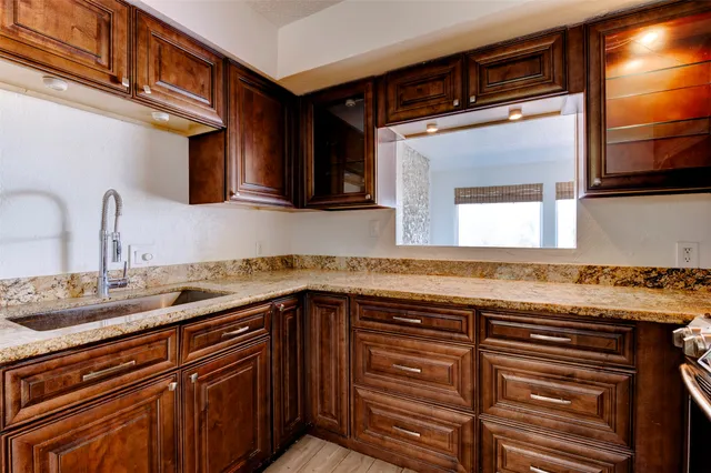 a kitchen with granite countertop a sink and cabinets