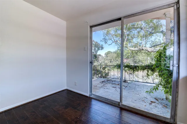 a view of a room with wooden floor and door