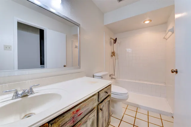 a bathroom with a sink a toilet a mirror and shower