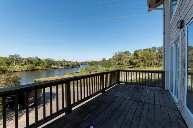 a balcony with wooden floor and lake view