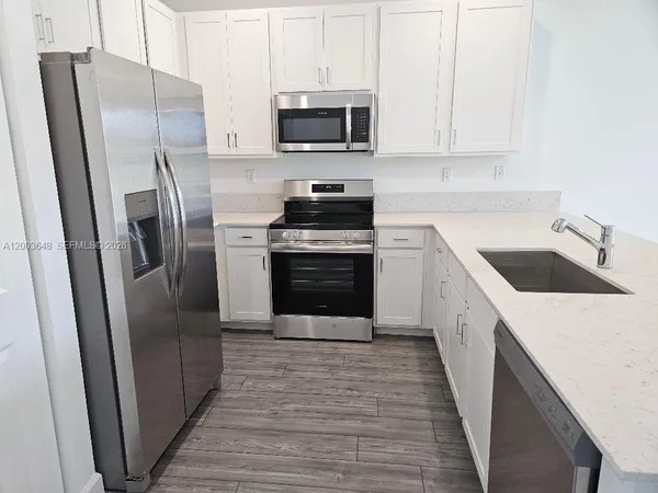 a kitchen with a sink and a wooden floor