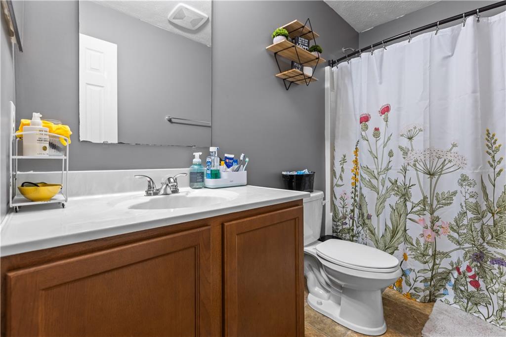421 Colt Circle Clinton, PA 15026 - Photo 25 of 32 a bathroom with a granite countertop sink a toilet and a shower curtain