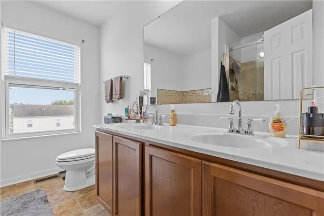a bathroom with a sink a toilet and a large mirror