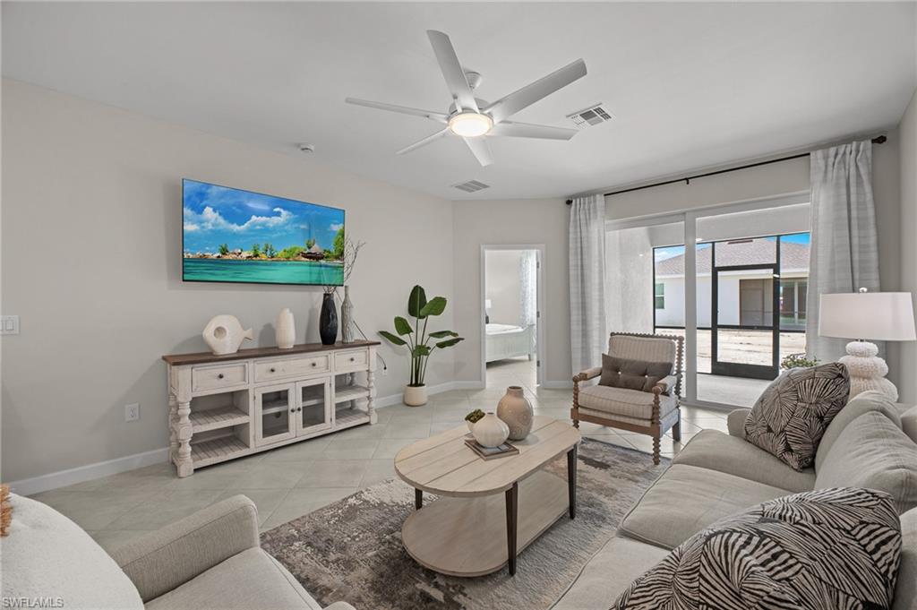 Living room with ceiling fan and light tile patterned flooring