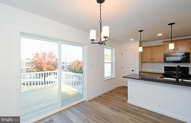 a living room with stainless steel appliances kitchen island wooden floors and view living room