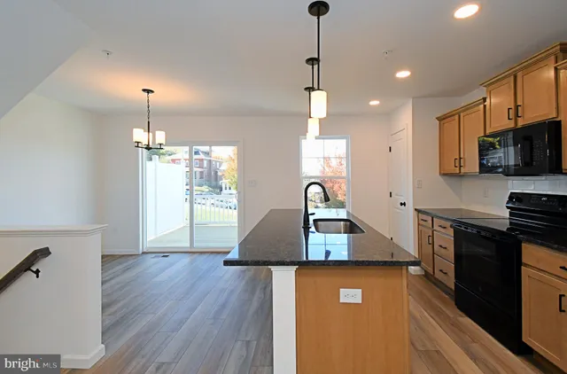 a view of a hallway with wooden floor and a chandelier