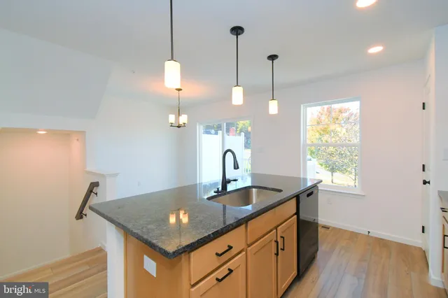 a view of a kitchen with wooden floor and outdoor space