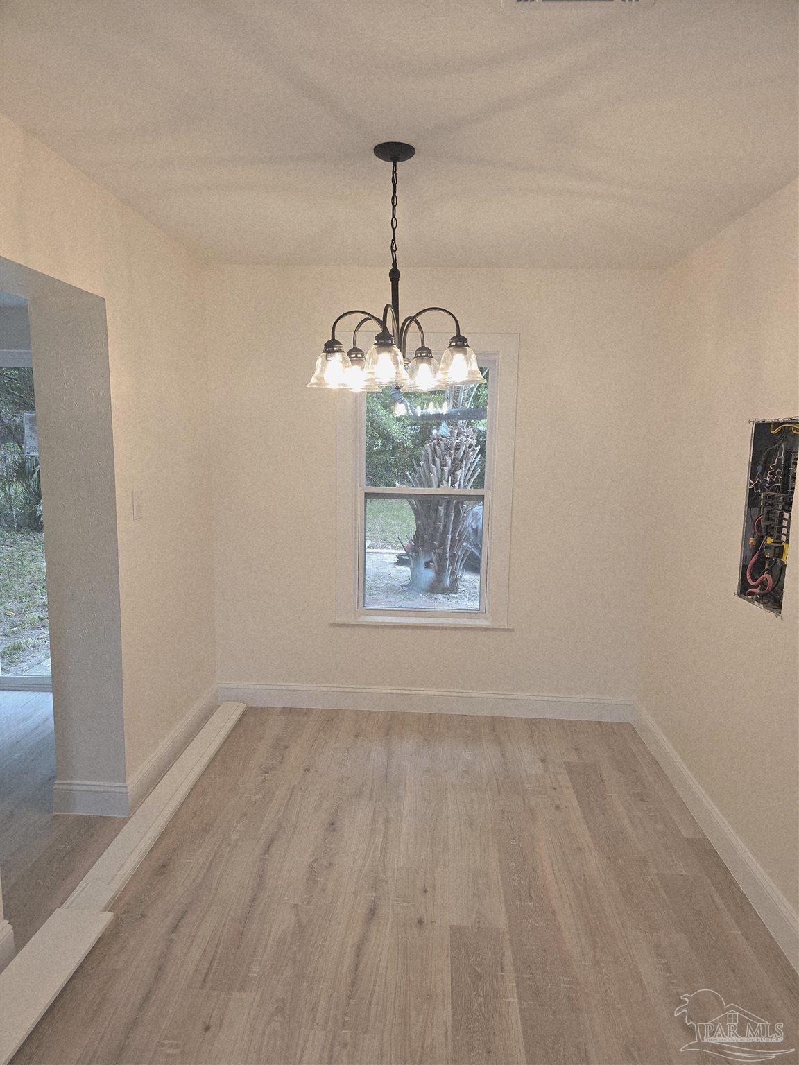 302 Dixie Street Crestview, FL 32536 - Photo 12 of 17 a view of wooden floor chandelier and window in a room