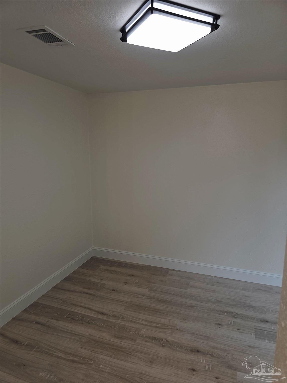 302 Dixie Street Crestview, FL 32536 - Photo 13 of 17 a view of a small space with wooden floor and white walls