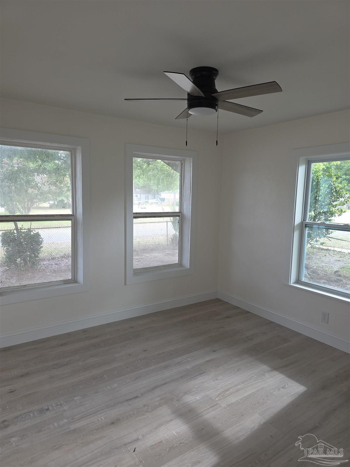 302 Dixie Street Crestview, FL 32536 - Photo 15 of 17 an empty room with wooden floor fan and windows