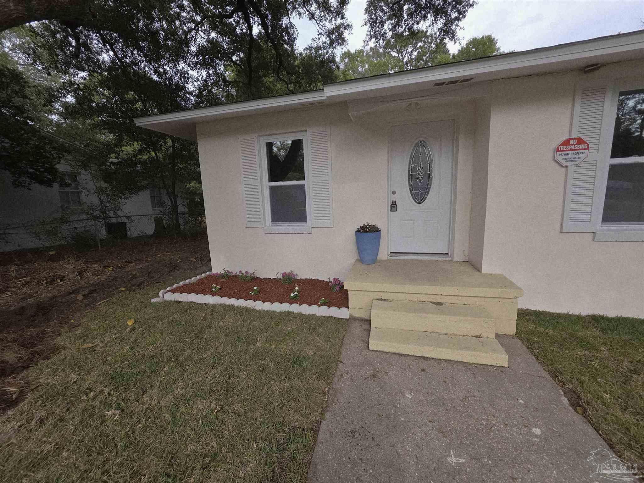 302 Dixie Street Crestview, FL 32536 - Photo 5 of 17 a view of backyard with a large tree and wooden fence