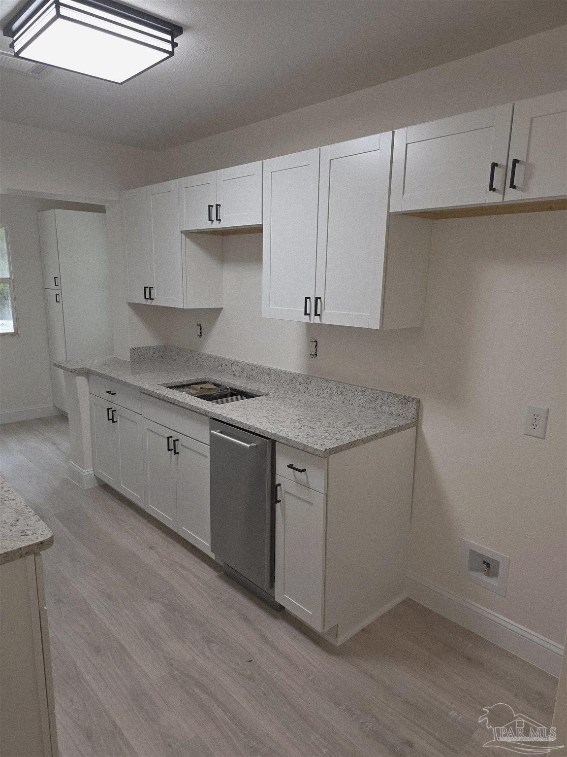 302 Dixie Street Crestview, FL 32536 - Photo 8 of 17 a kitchen with a sink cabinets and wooden floor