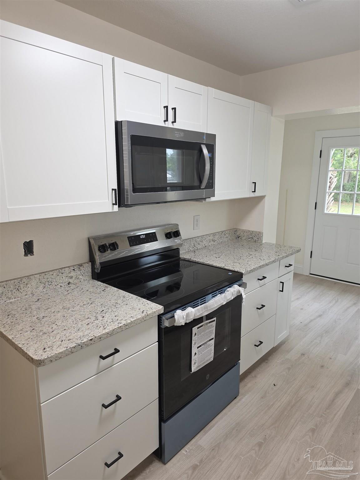 302 Dixie Street Crestview, FL 32536 - Photo 9 of 17 a kitchen with granite countertop a stove and a microwave