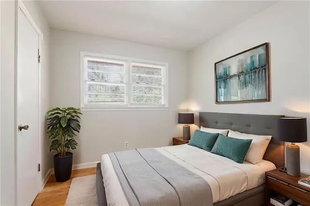 a bedroom with a large bed and a potted plant