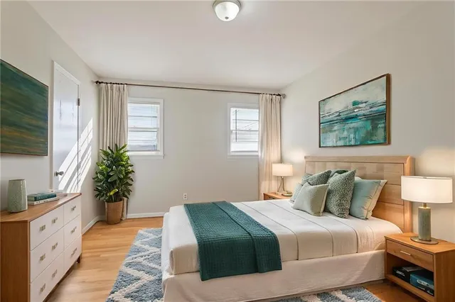 a bedroom with a large bed and a flat tv screen on dresser