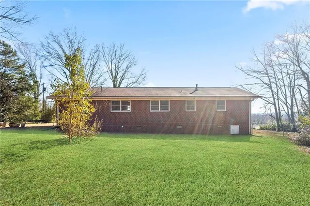a view of a yard in front of a house with large tree