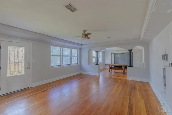 a view of empty room with wooden floor and a ceiling fan
